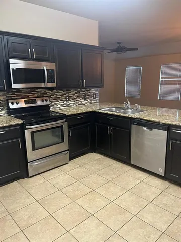 a kitchen with stainless steel appliances granite countertop a stove top oven microwave and cabinets