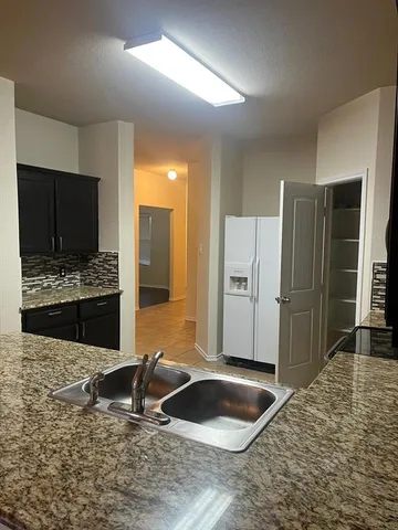 a kitchen with a stove a refrigerator and a sink