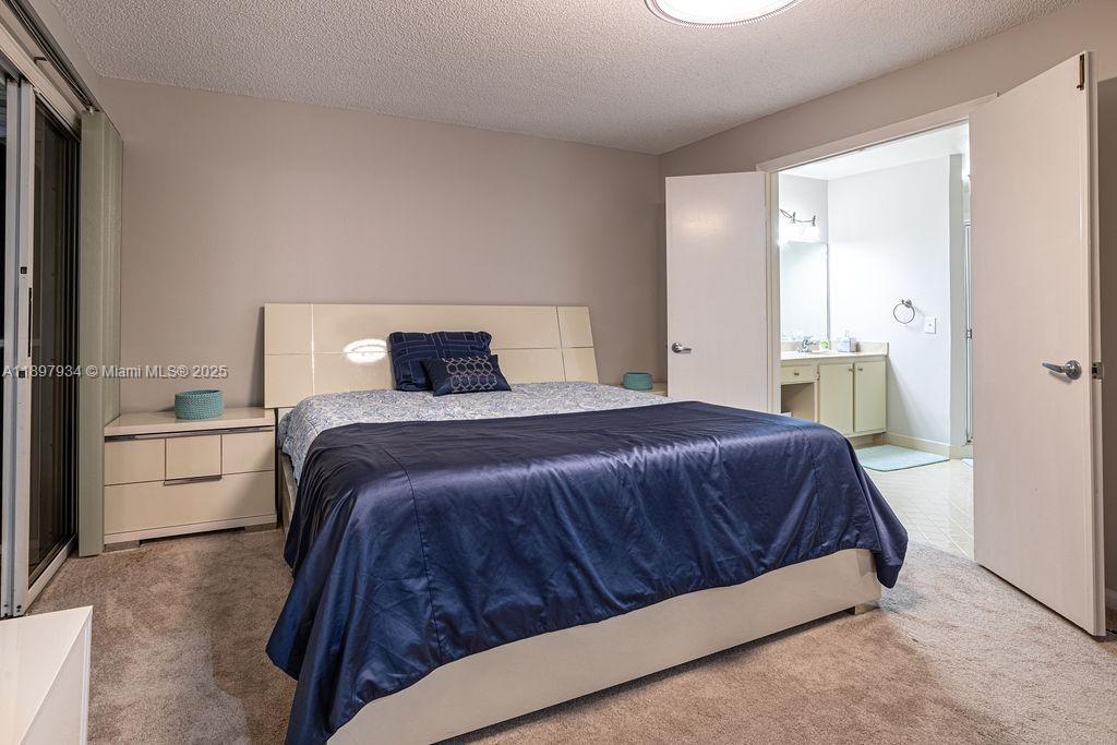 6500 Via Regina, Unit 8 Boca Raton, FL 33433 - Photo 11 of 31 a bedroom with a bed and a dresser
