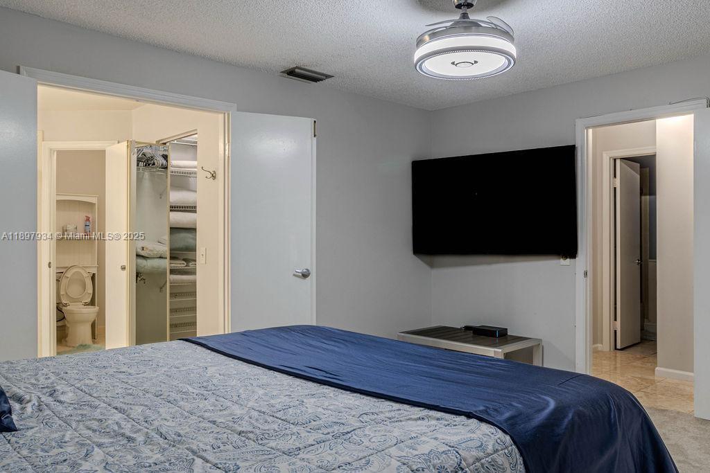 6500 Via Regina, Unit 8 Boca Raton, FL 33433 - Photo 12 of 31 a bedroom with a bed and a flat screen tv