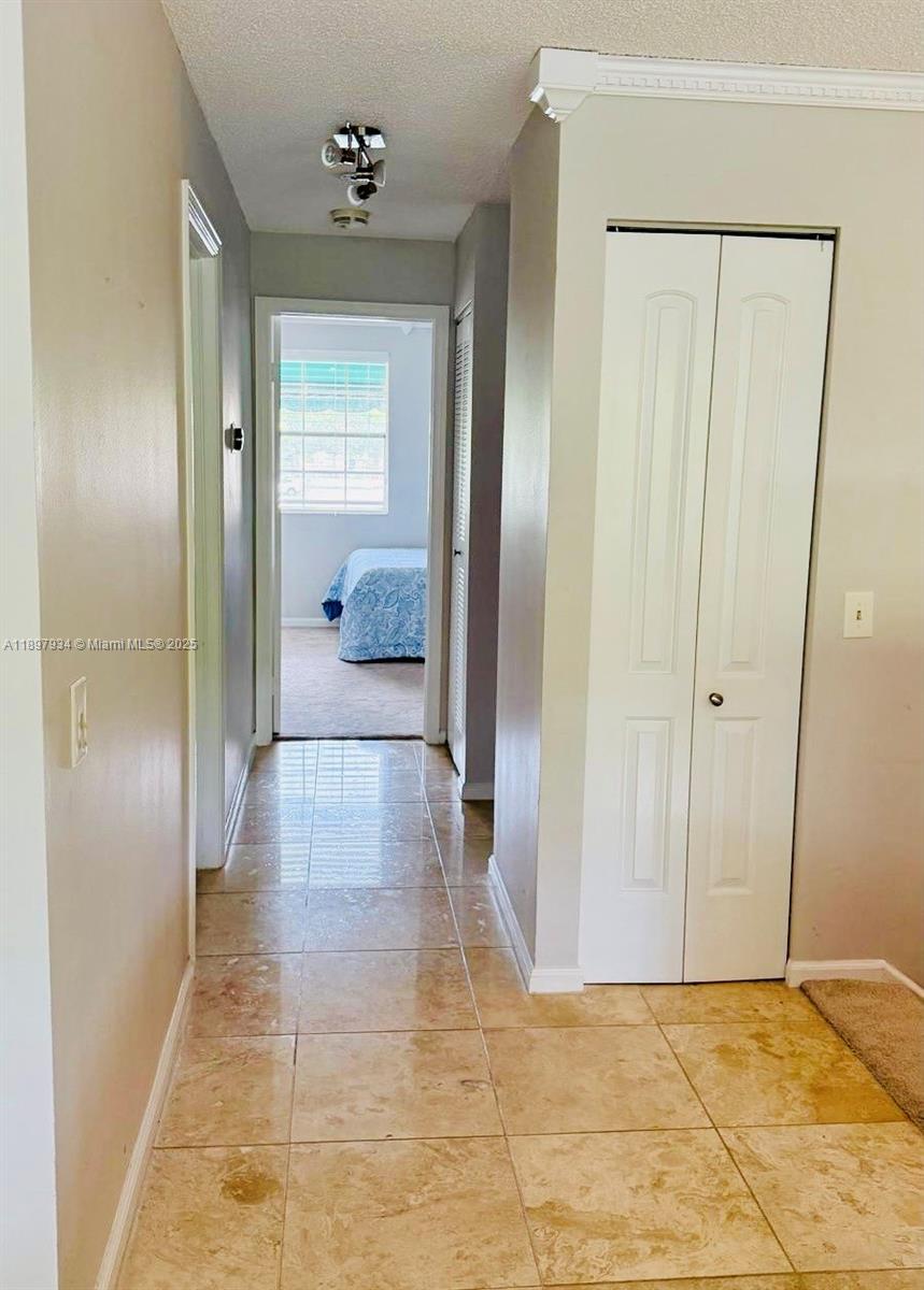 6500 Via Regina, Unit 8 Boca Raton, FL 33433 - Photo 24 of 31 a view of a hallway with a chandelier