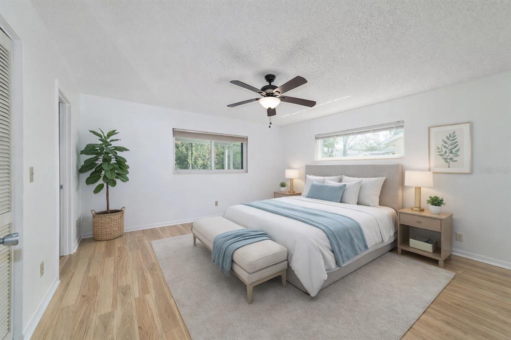 8877 Southwest 96th Street, Unit D Ocala, FL 34481 - Photo 29 of 51 a spacious bedroom with a large bed and a chandelier