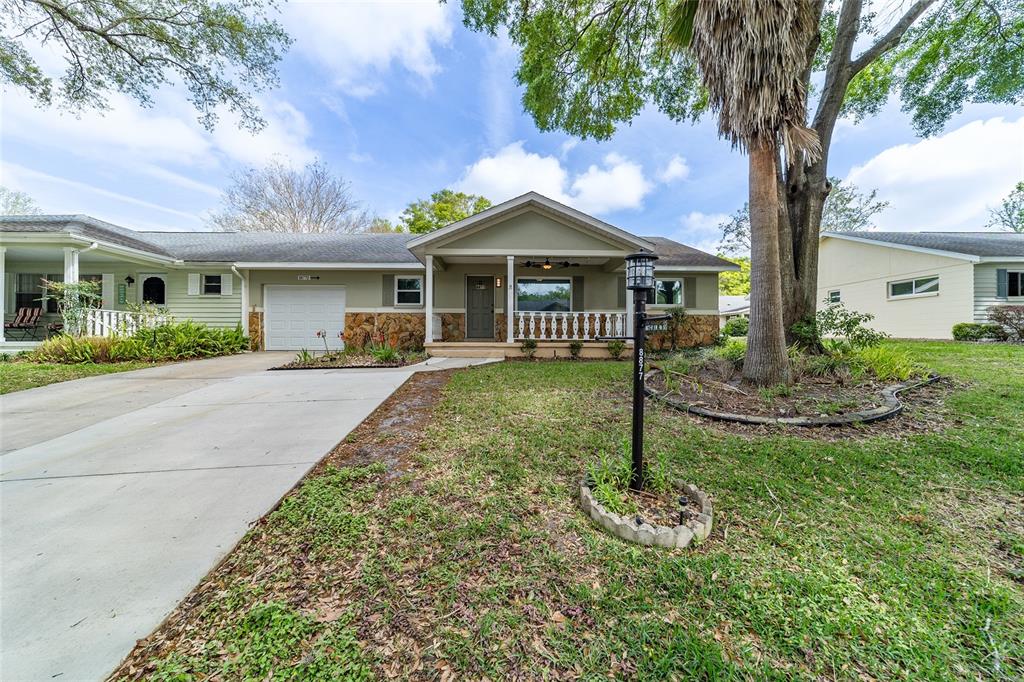 8877 Southwest 96th Street, Unit D Ocala, FL 34481 - Photo 4 of 51 a front view of a house with a yard and tree