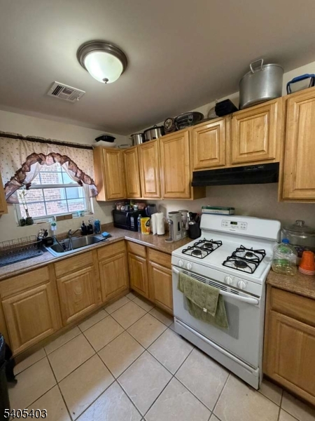 91 Spruce Street Newark, NJ 07102 - Photo 16 of 34 a kitchen with cabinets appliances a sink and a window
