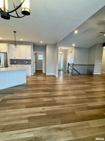 a view of a kitchen with stainless steel appliances granite countertop a sink and a stove