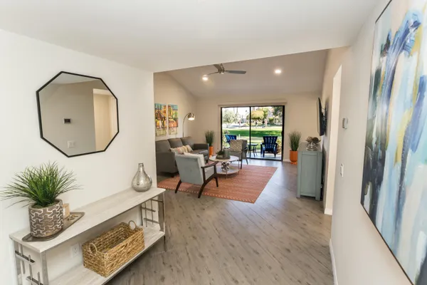 a living room with furniture wooden floor and a large mirror