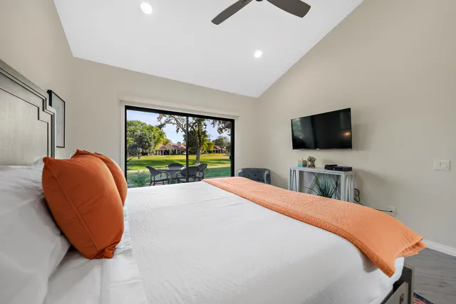 a bedroom with a large bed and a flat screen tv