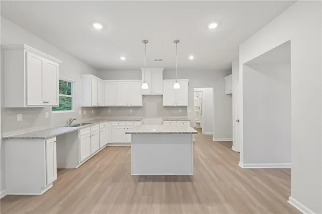 a large kitchen with cabinets wooden floor and stainless steel appliances