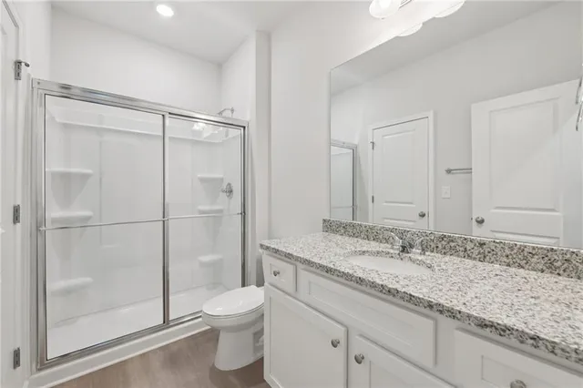 a bathroom with a granite countertop sink toilet and shower