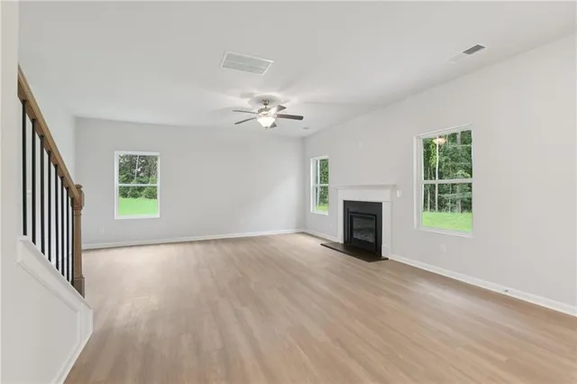 an empty room with windows and fireplace