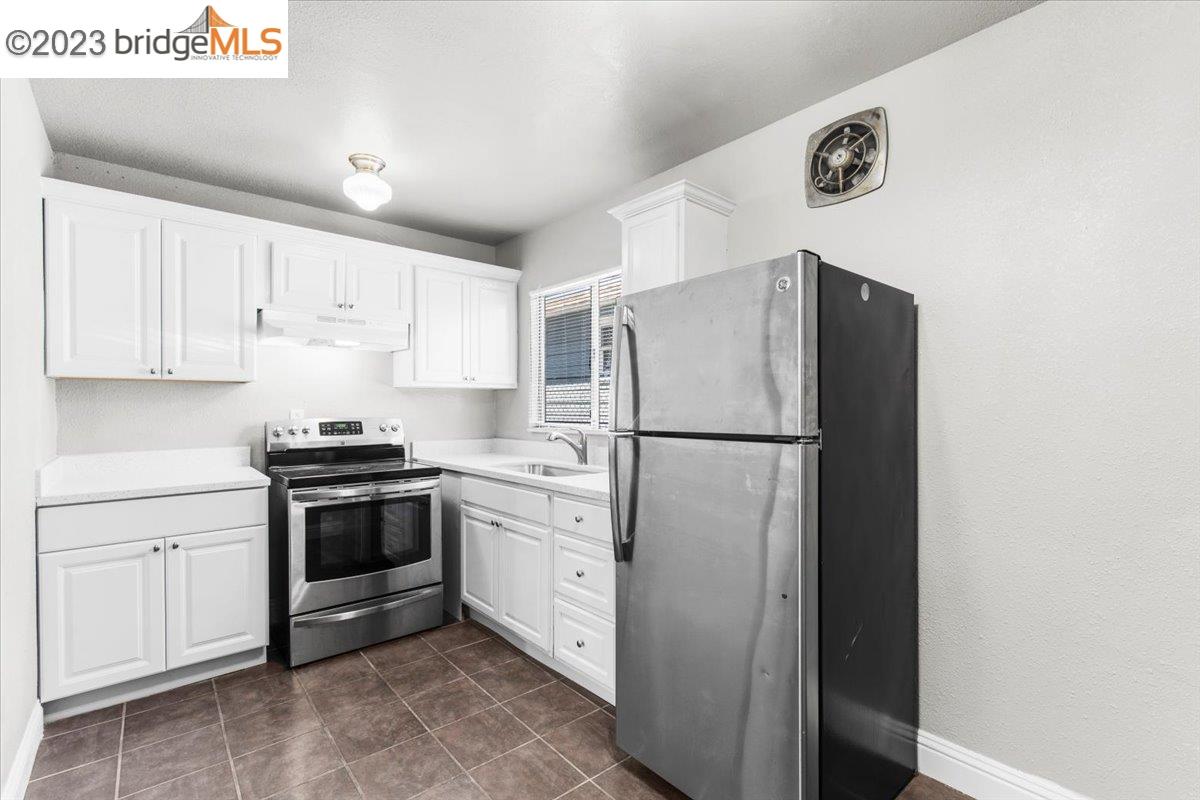 1813 63rd Street, Unit A Berkeley, CA 94703 - Photo 22 of 37 a kitchen with stainless steel appliances granite countertop a refrigerator sink and stove