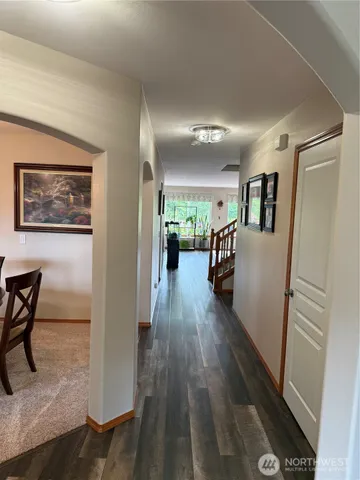 a view of a hallway with wooden floor and furniture