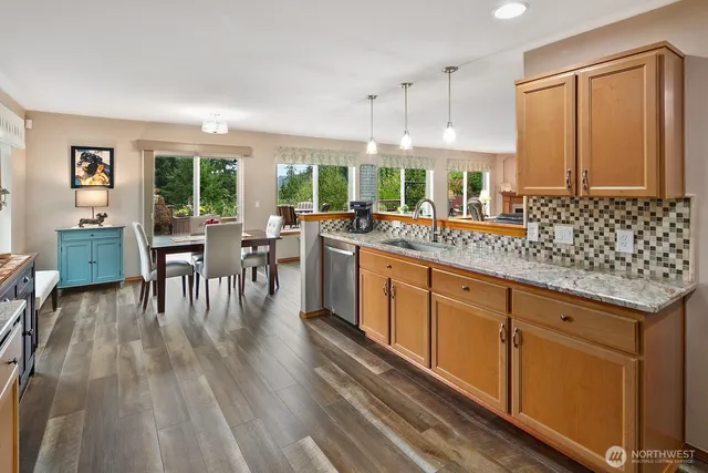 a kitchen with stainless steel appliances granite countertop wooden floors and white cabinets