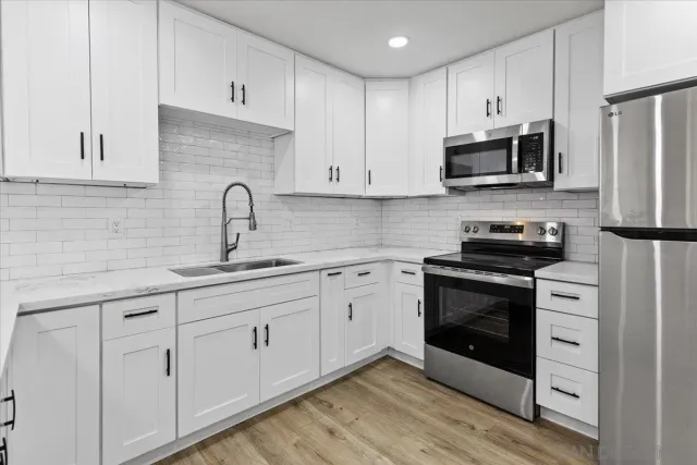 a kitchen with a refrigerator a microwave a sink and cabinets