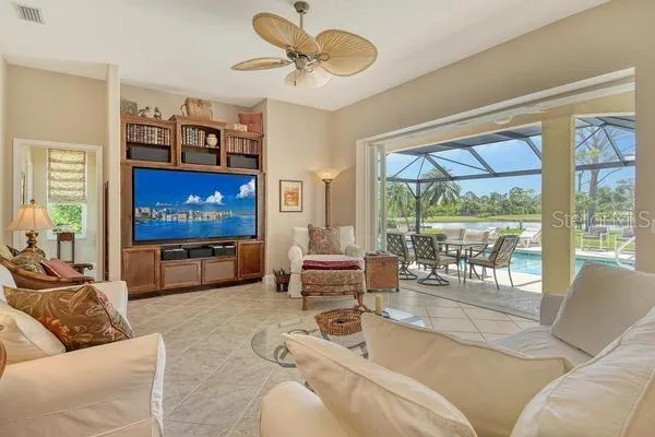 a living room with furniture a large window and a flat screen tv