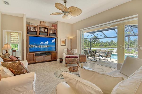 9477 Cedar Ridge Lane Sarasota, FL 34238 - Photo 17 of 51 a living room with furniture a large window and a flat screen tv