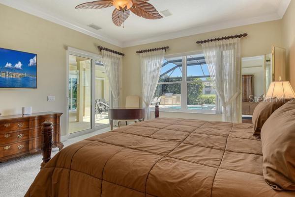 9477 Cedar Ridge Lane Sarasota, FL 34238 - Photo 20 of 51 a bedroom with a large bed and a tv