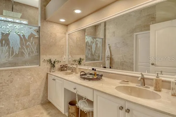 a bathroom with double sink and a mirror