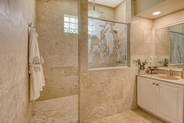 9477 Cedar Ridge Lane Sarasota, FL 34238 - Photo 22 of 51 a bathroom with a shower sink and mirror