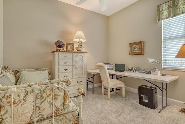 9477 Cedar Ridge Lane Sarasota, FL 34238 - Photo 24 of 51 a room with a bed and a table