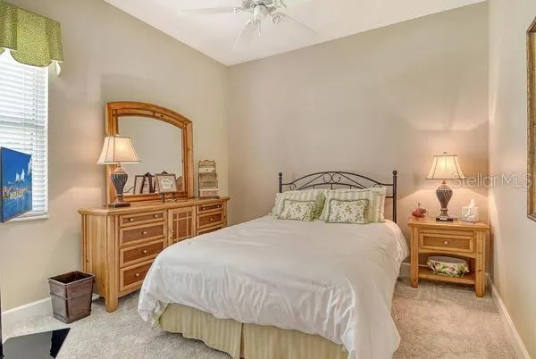 a bedroom with a bed and a dresser with mirror