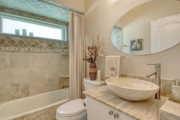 9477 Cedar Ridge Lane Sarasota, FL 34238 - Photo 27 of 51 a bathroom with a granite countertop bathtub sink vanity mirror and toilet