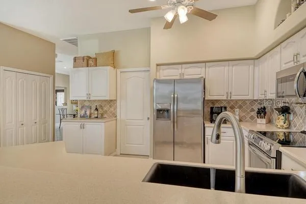 a kitchen with stainless steel appliances a refrigerator sink and cabinets