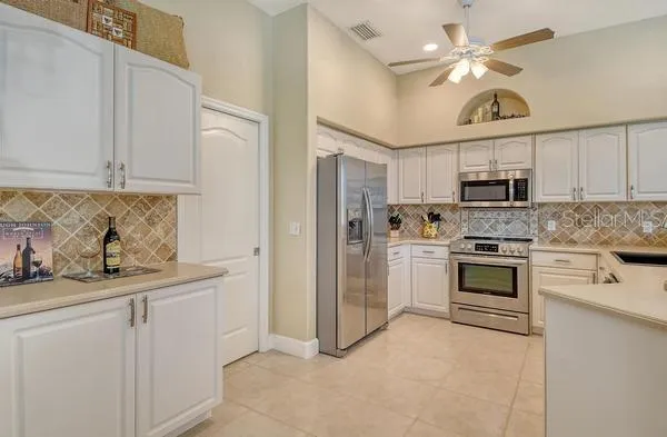 a kitchen with stainless steel appliances granite countertop a stove a sink and a refrigerator
