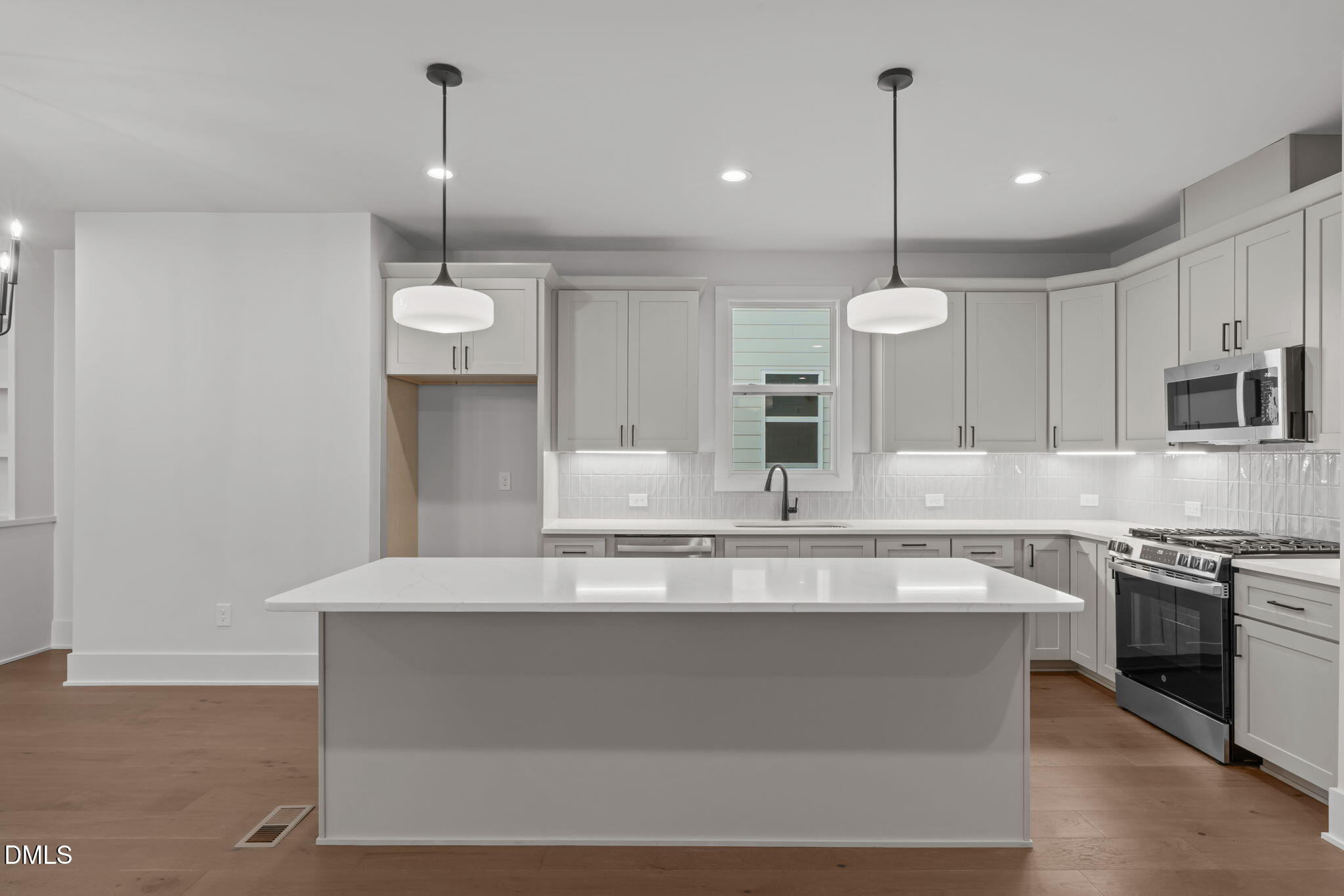 635 Conover Road, Unit A Durham, NC 27703 - Photo 10 of 48 a large kitchen with stainless steel appliances kitchen island a large island in the center