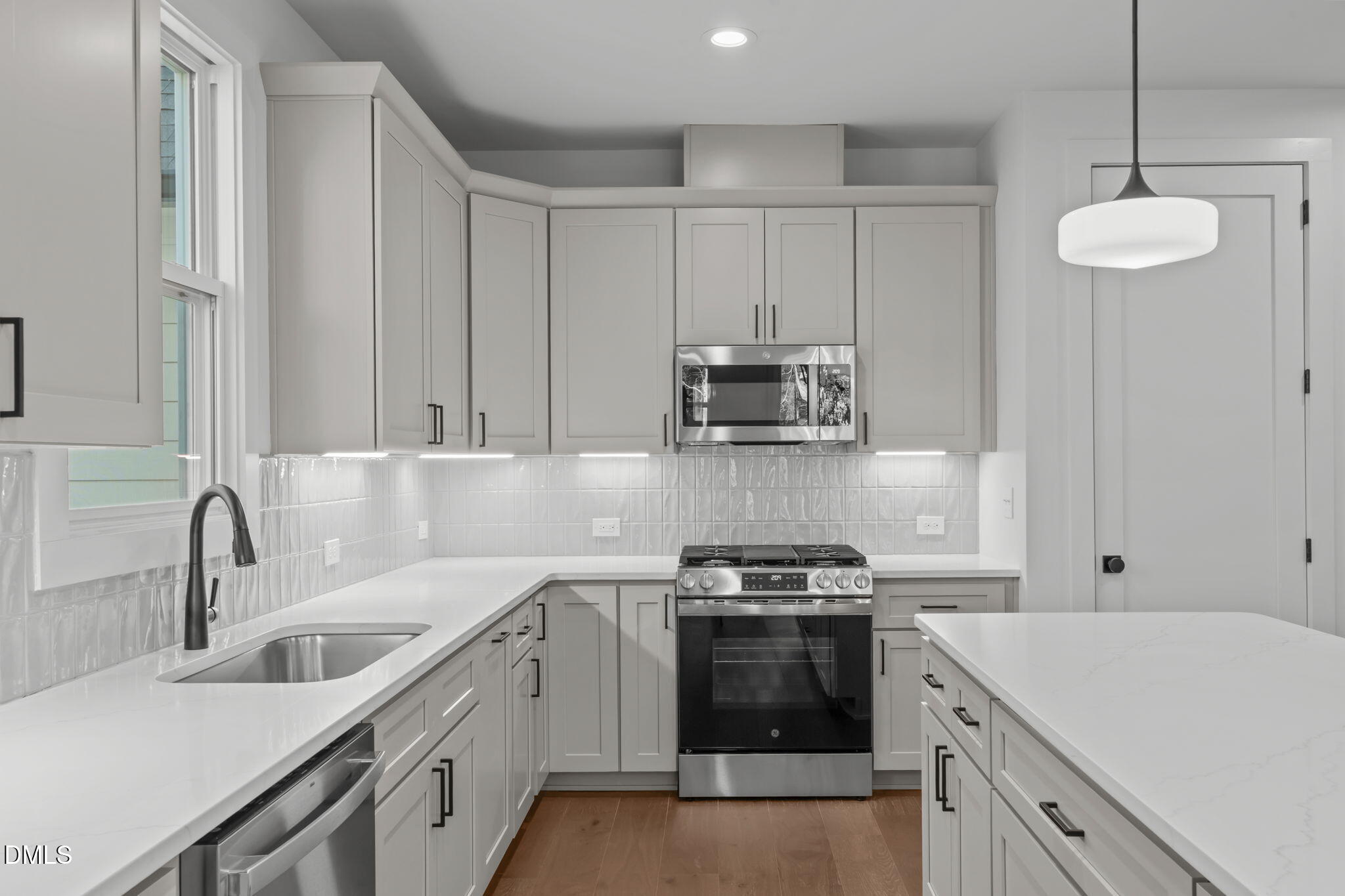 635 Conover Road, Unit A Durham, NC 27703 - Photo 12 of 48 a kitchen with stainless steel appliances a sink stove and white cabinets