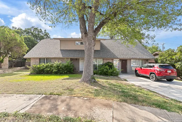a front view of a house with yard and greenery