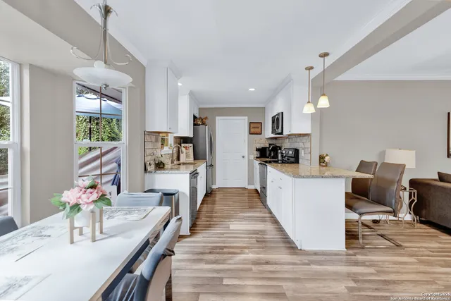 a view of kitchen with refrigerator stove and wooden floor