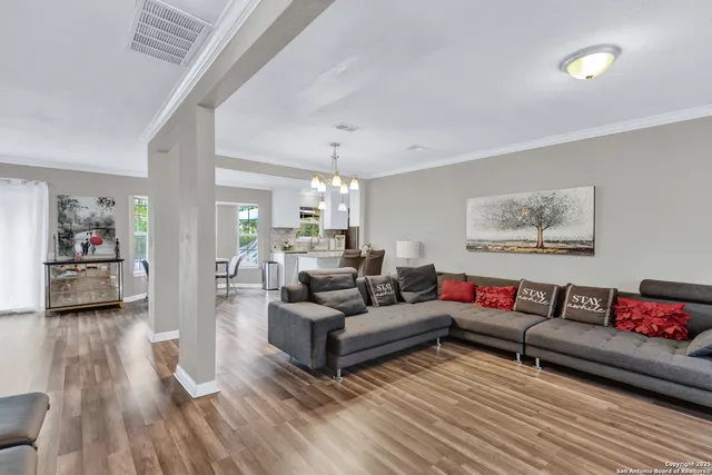 a living room with furniture and a wooden floor