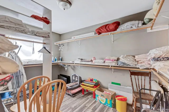 a utility room with stainless steel appliances wooden floor and couch