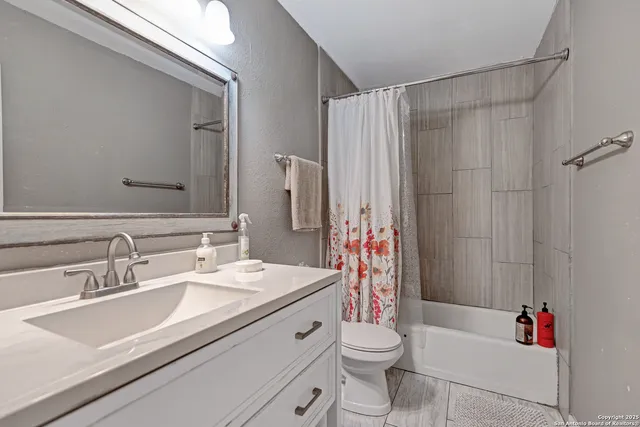 a bathroom with a sink toilet vanity and shower