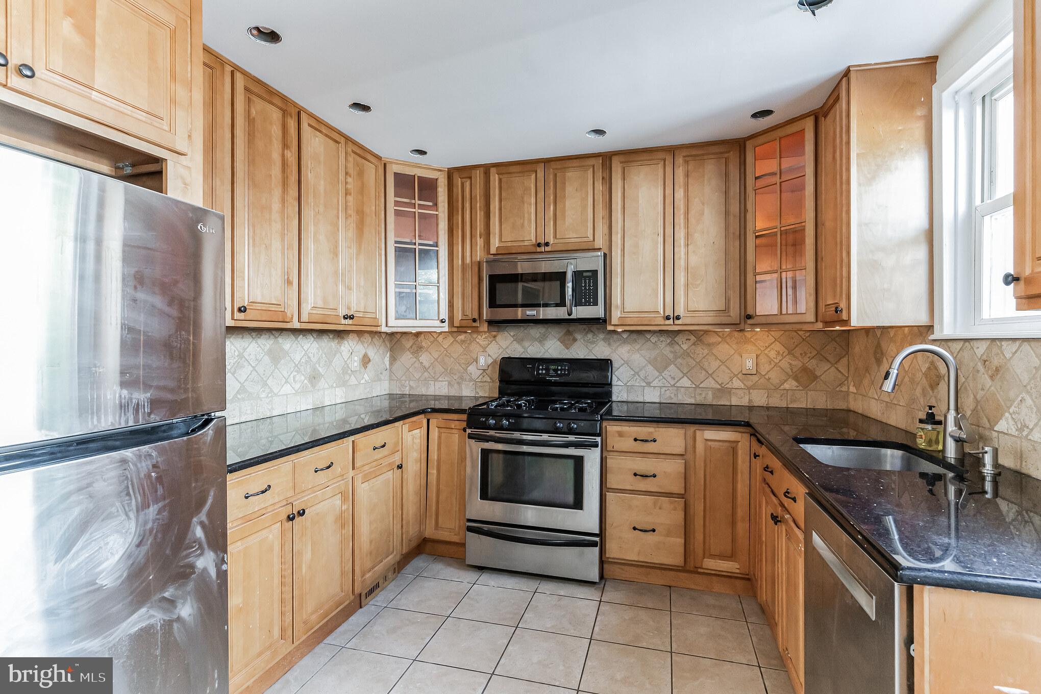 223 Fitzwilliams Road Bryn Mawr, PA 19010 - Photo 8 of 29 a kitchen with stainless steel appliances granite countertop a sink stove microwave and cabinets