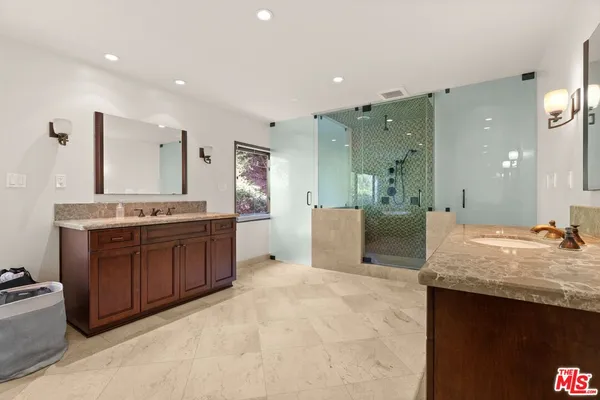 a spacious bathroom with a granite countertop sink and a mirror