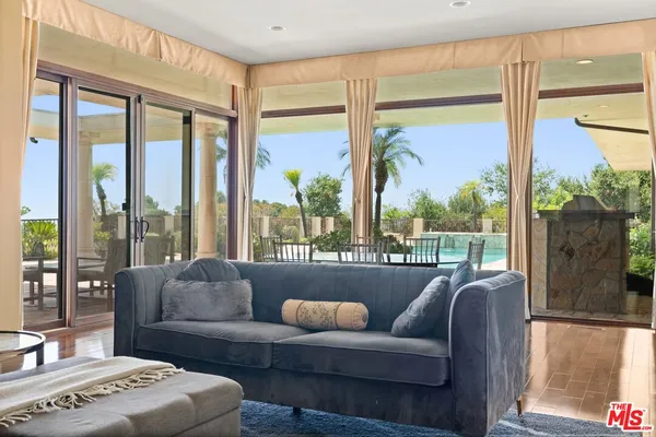 a view of a dining room with furniture and large windows