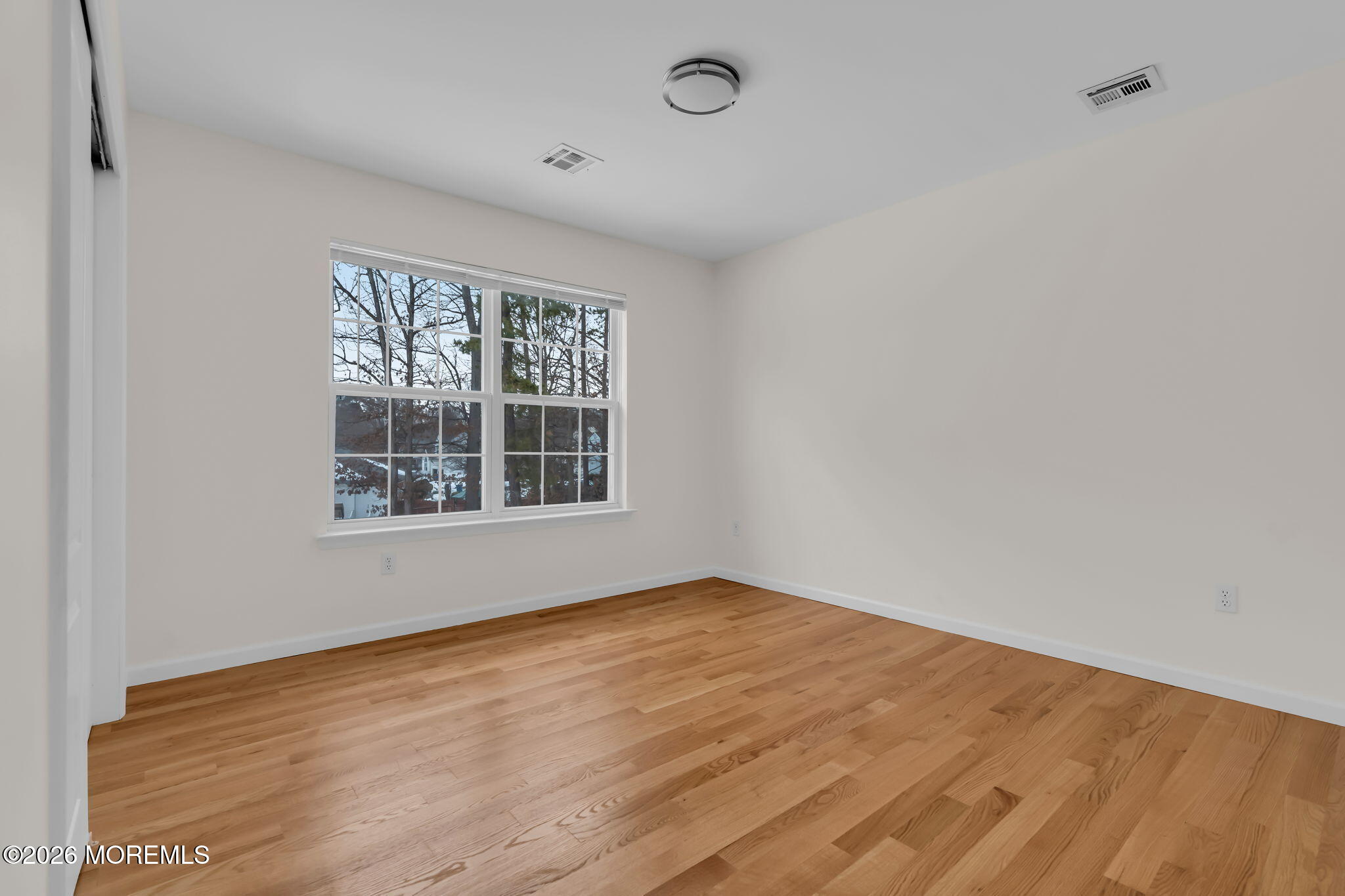 482 Meadowood Road Jackson, NJ 08527 - Photo 4 of 51 a view of an empty room with wooden floor and a window