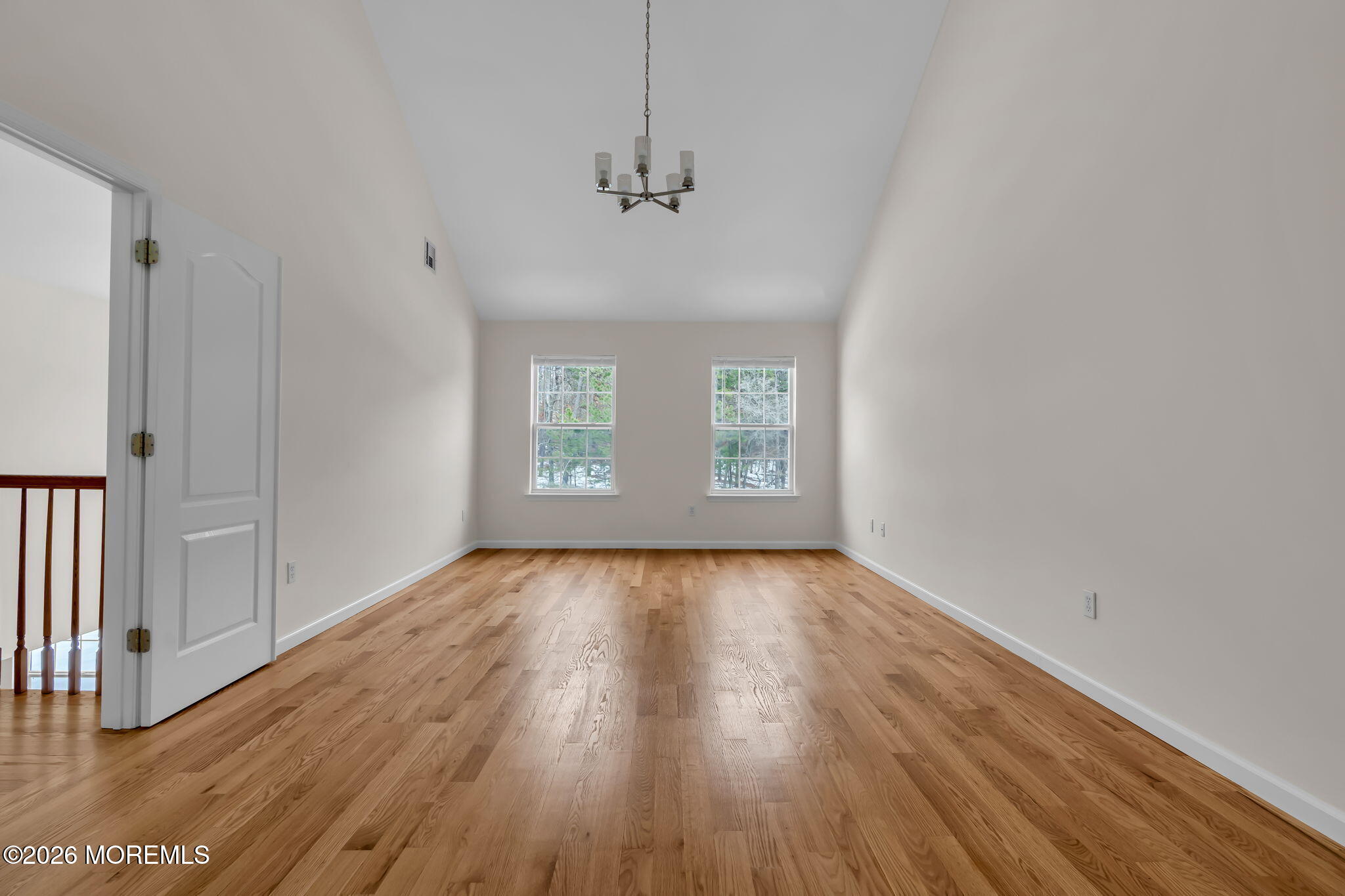 482 Meadowood Road Jackson, NJ 08527 - Photo 7 of 51 an empty room with wooden floor chandelier and windows