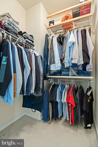 a view of walk in closet with clothes and shoes