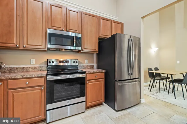 a kitchen with stainless steel appliances granite countertop a refrigerator stove and microwave