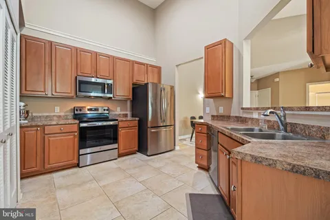 a kitchen with stainless steel appliances granite countertop a stove refrigerator sink and microwave