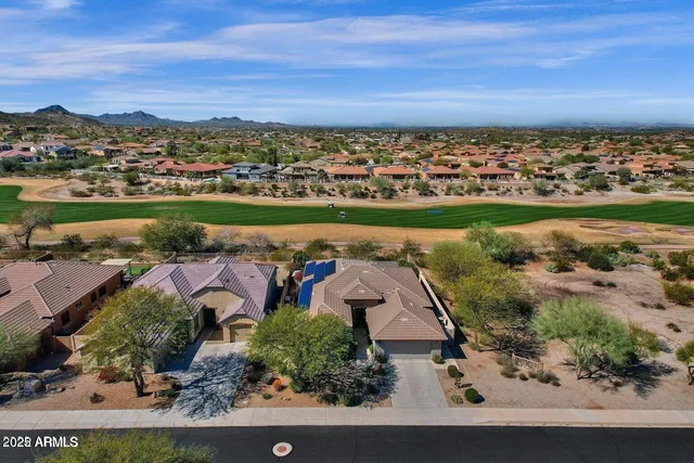 an aerial view of a city with lots of residential buildings ocean and mountain view in back