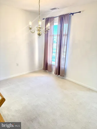 a view of a big room with windows and chandelier fan
