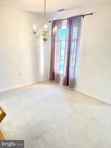 a view of a big room with windows and chandelier fan