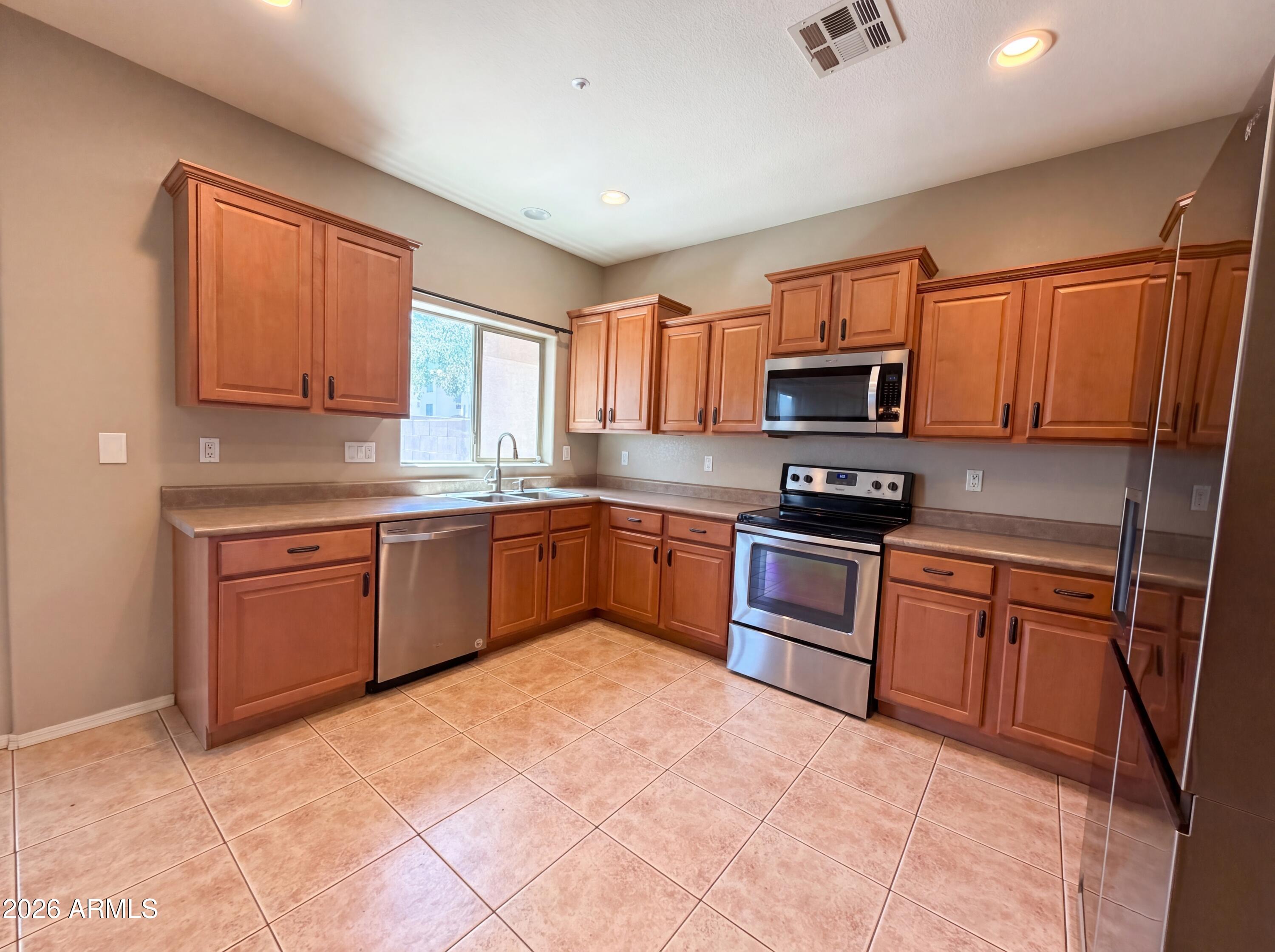 1565 East Hopkins Road Gilbert, AZ 85295 - Photo 19 of 29 a kitchen with stainless steel appliances granite countertop a stove sink microwave and refrigerator