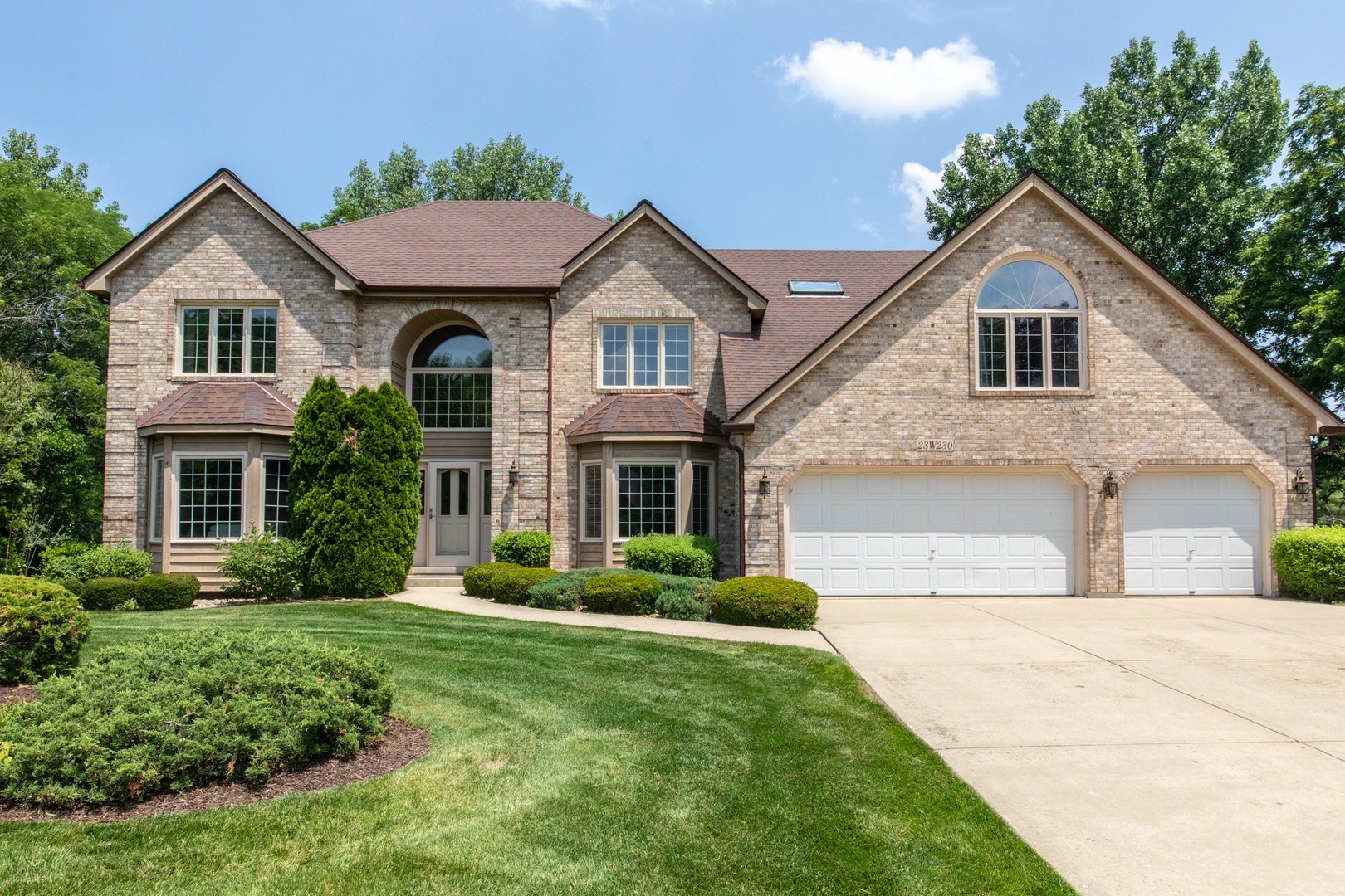 23W230 Hampton Circle Naperville, IL 60540 - Photo 1 of 55 a front view of a house with a yard and garage