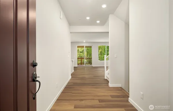 a view of a hallway with wooden floor and windows