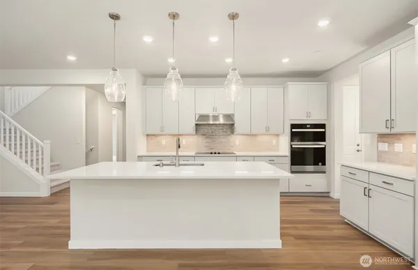 a large kitchen with stainless steel appliances kitchen island a large counter top and a sink